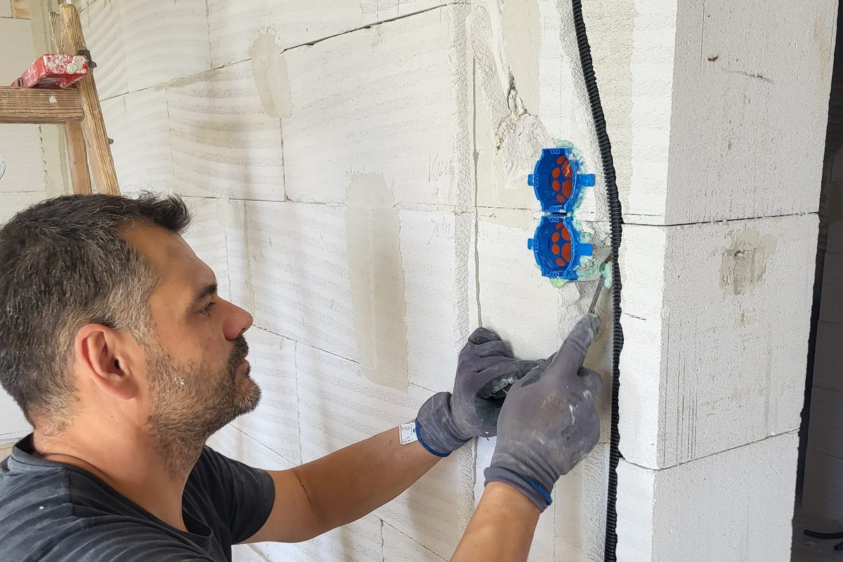 Christian Gradinger setzt Schalterdosen in eine Rohbauwand ein